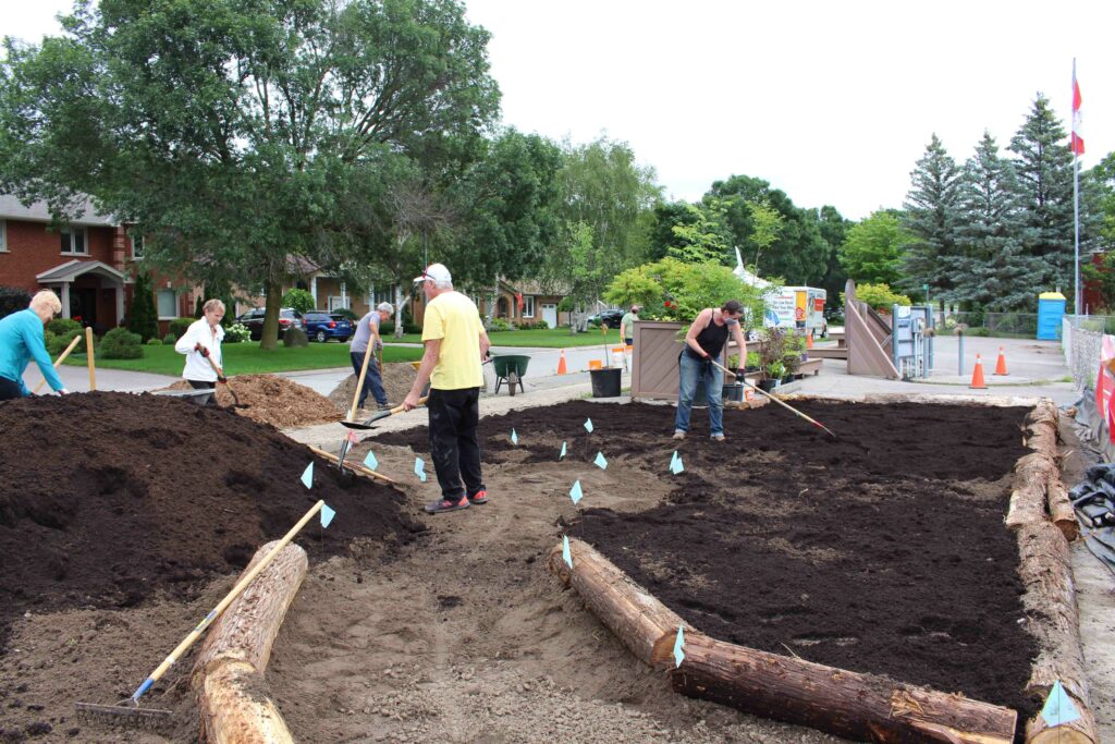 Volunteers laying new soil to support a Depave project planting. Lakefield, Ontario, August 2021. Image courtesy of Depave Paradise Program, Green Communities Canada.